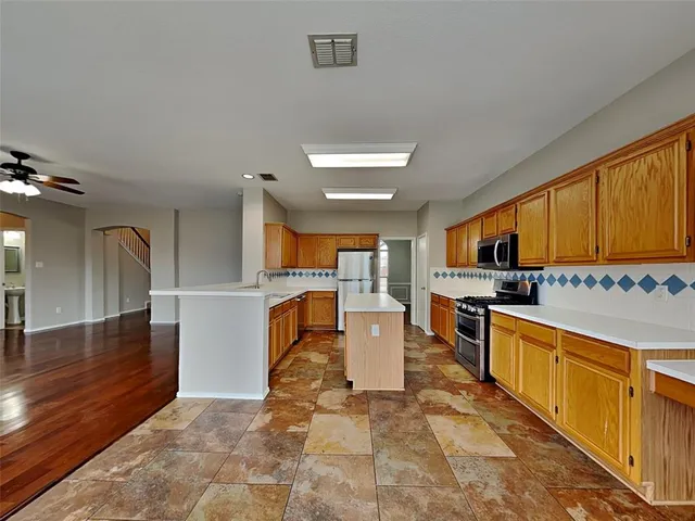 a kitchen with stainless steel appliances granite countertop a sink stove and cabinets