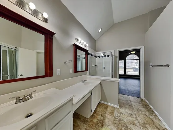 a spacious bathroom with a tub a sink and mirror