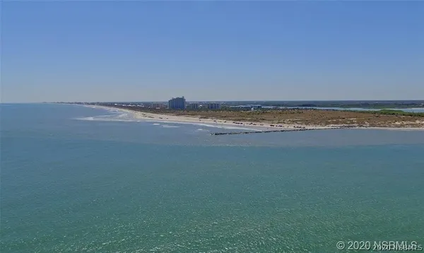 a front view of a house with a yard and potted plants