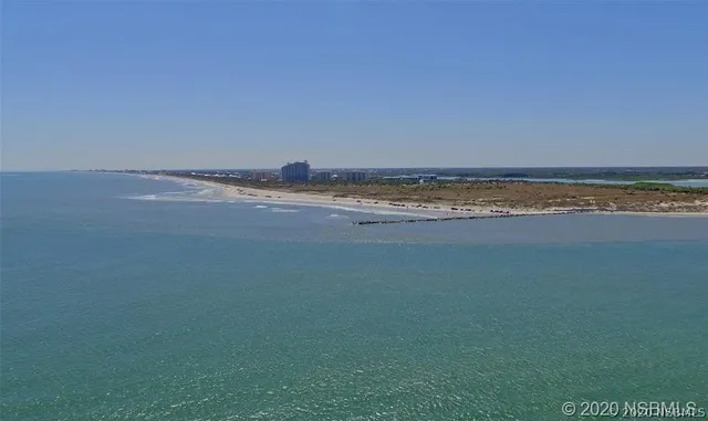 a front view of a house with a yard and potted plants