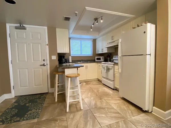 a kitchen with white cabinets and white appliances