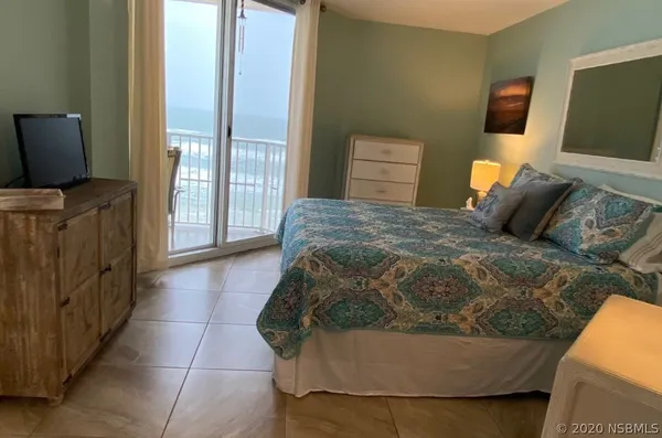 a bedroom with a bed and flat screen tv