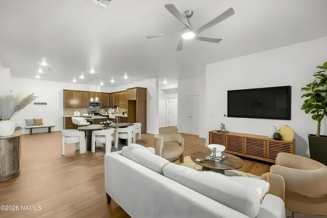 a living room with furniture kitchen view and a flat screen tv
