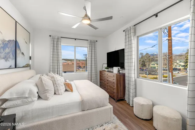 a bedroom with a large bed and a flat tv screen