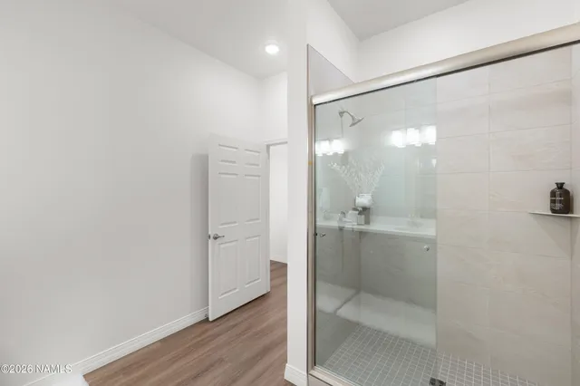 a bathroom with a glass shower door and a sink