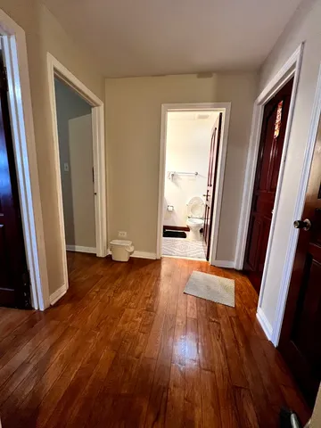 an empty room with wooden floor and a window
