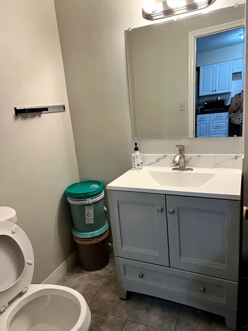 a bathroom with a granite countertop toilet sink and mirror