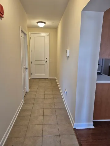 a view of a hallway with wooden floor and a cabinet