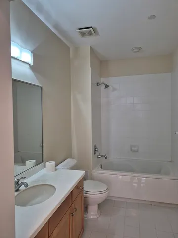 a bathroom with a granite countertop sink a toilet and shower