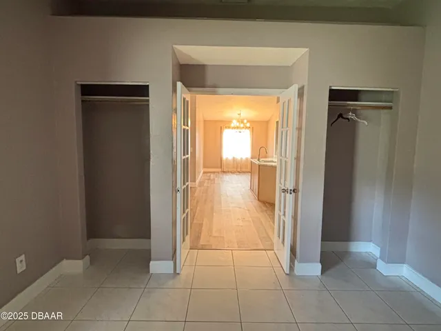 a view of a hallway with wooden floor and a bathroom
