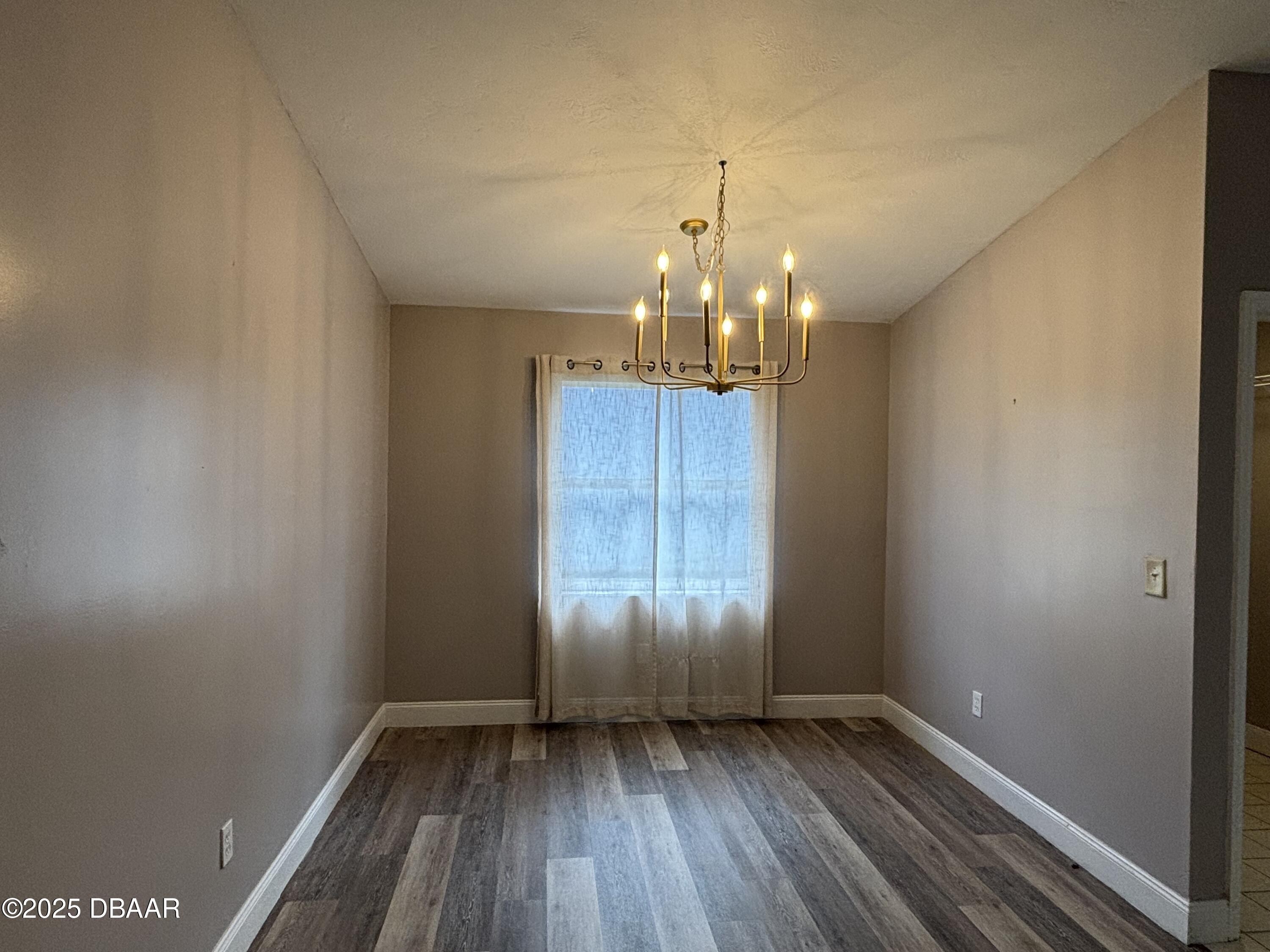 5426 Landis Avenue Port Orange, FL 32127 - Photo 6 of 30 a view of an empty room with wooden floor and window