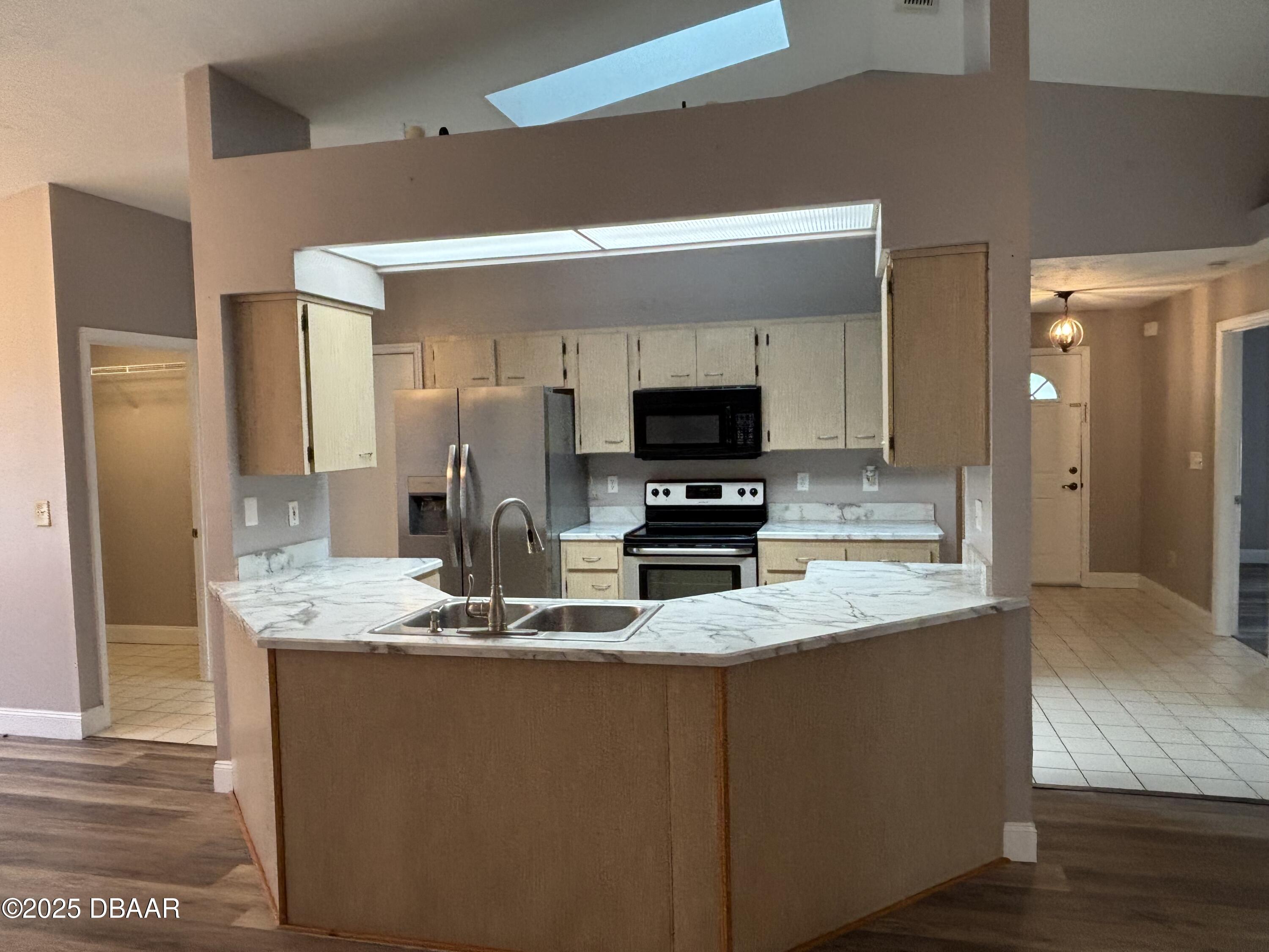 5426 Landis Avenue Port Orange, FL 32127 - Photo 7 of 30 a kitchen with kitchen island granite countertop stainless steel appliances a stove refrigerator sink and microwave
