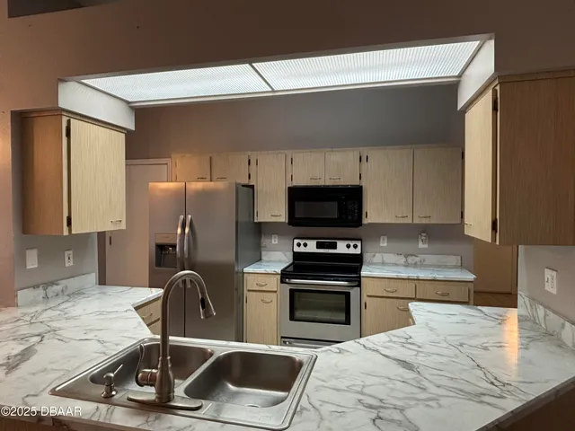 a kitchen with a sink a stove and a microwave