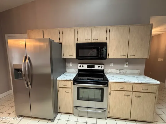 a kitchen with stainless steel appliances granite countertop a refrigerator stove and microwave