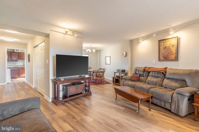 a living room with furniture a flat screen tv and wooden floor