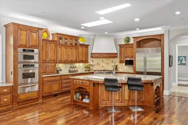 a kitchen with granite countertop stove and cabinets