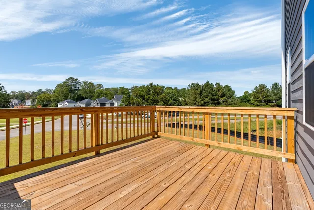 a view of balcony with wooden floor & fence