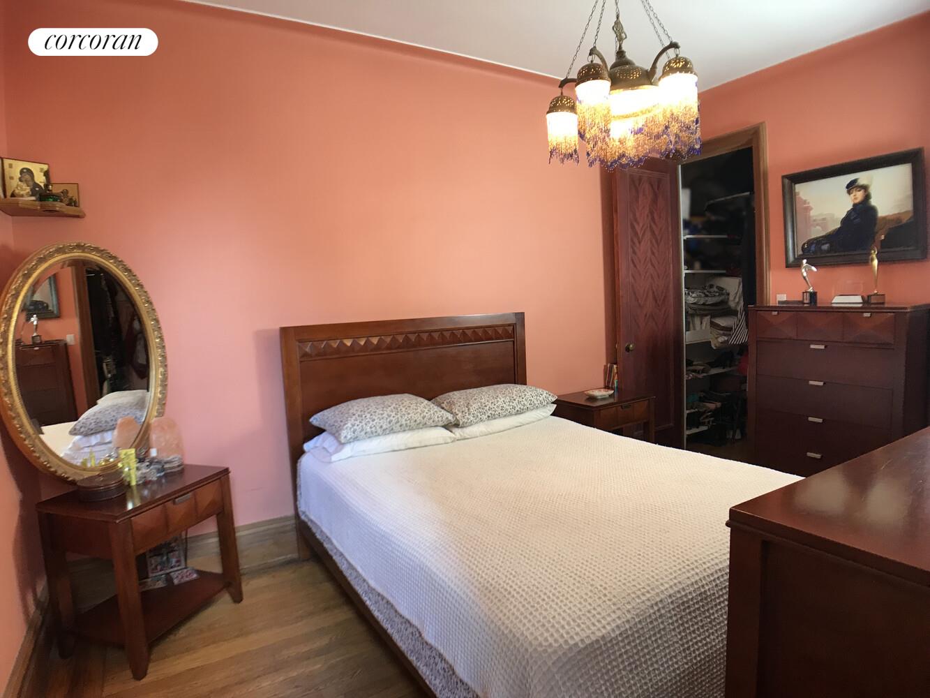 790 Riverside Drive, Unit 7C Manhattan, NY 10032 - Photo 8 of 12 a bedroom with a bed and a chandelier