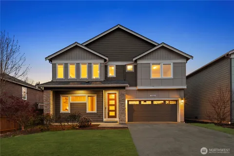 a front view of a house with a yard and garage