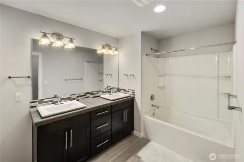 a bathroom with a tub sink and mirror