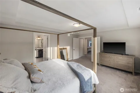 a spacious bedroom with a bed and a flat screen tv