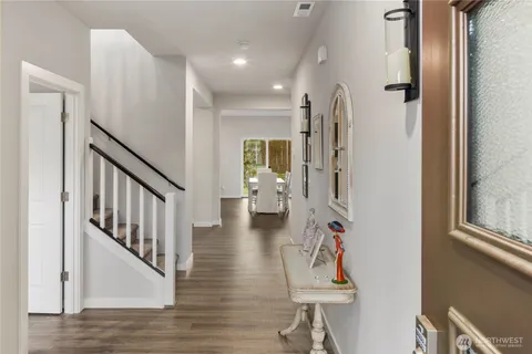 a hallway with wooden floor windows and stairs