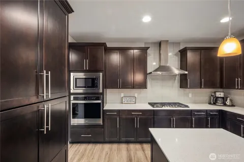 a kitchen with stainless steel appliances granite countertop a refrigerator and a stove top oven