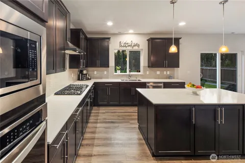 a kitchen with kitchen island granite countertop a sink and a stove
