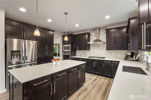 a kitchen with a sink a counter top space stainless steel appliances and cabinets