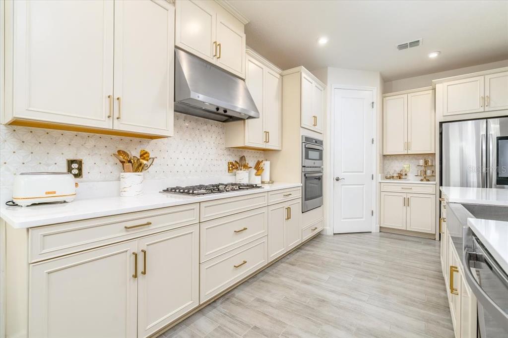 1296 Waterview Ridge Circle Apopka, FL 32703 - Photo 24 of 60 a kitchen with white cabinets and stainless steel appliances