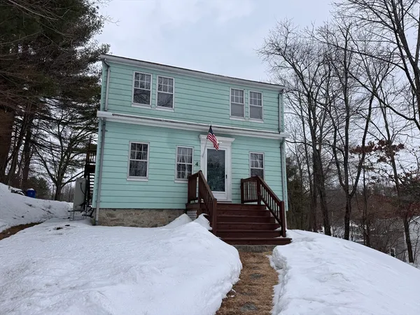 a view of a house with a yard covered in snow