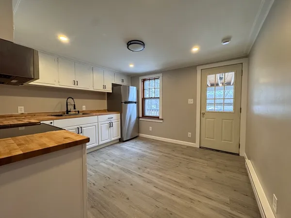 a kitchen with granite countertop a sink cabinets and stainless steel appliances