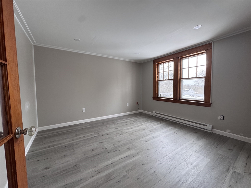 4 James Street, Unit 2 Dudley, MA 01571 - Photo 8 of 15 an empty room with wooden floor and windows