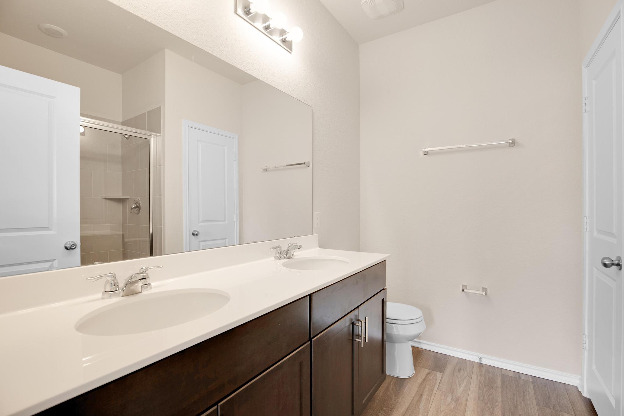 200 Janice Road Taylor, TX 76574 - Photo 13 of 25 A well-appointed bathroom offers a double vanity and a convenient walk-in shower.