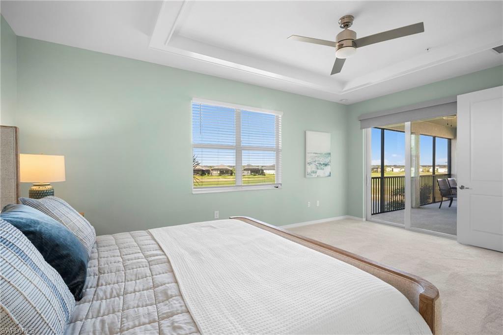 15194 Bluffton Lane, Unit 1422 Babcock Ranch, FL 33982 - Photo 23 of 35 a bedroom with a large bed and a chandelier