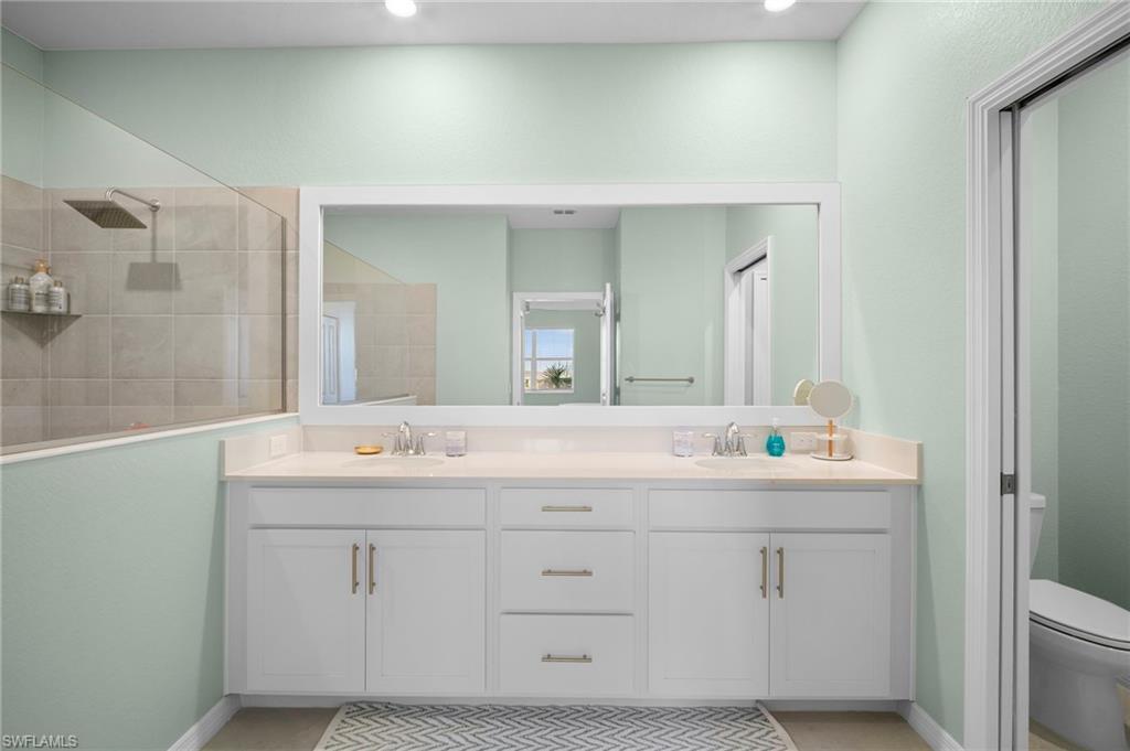 15194 Bluffton Lane, Unit 1422 Babcock Ranch, FL 33982 - Photo 26 of 35 a bathroom with a double vanity sink and mirror