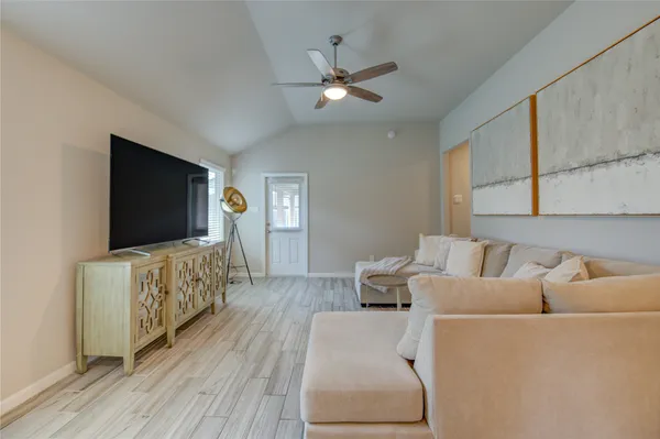 a kitchen with stainless steel appliances a refrigerator a stove a sink a dining table and chairs with wooden floor