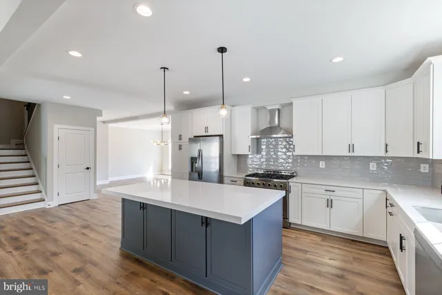 a kitchen with kitchen island a sink stainless steel appliances and cabinets