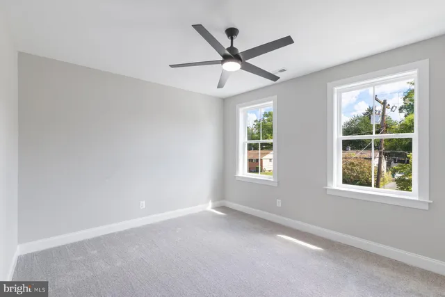 an empty room with a window and a fan