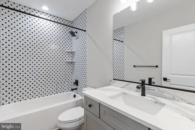 a bathroom with a sink a toilet and a mirror