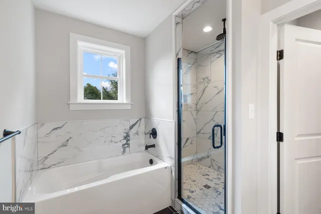 a bathroom with a bathtub shower and toilet