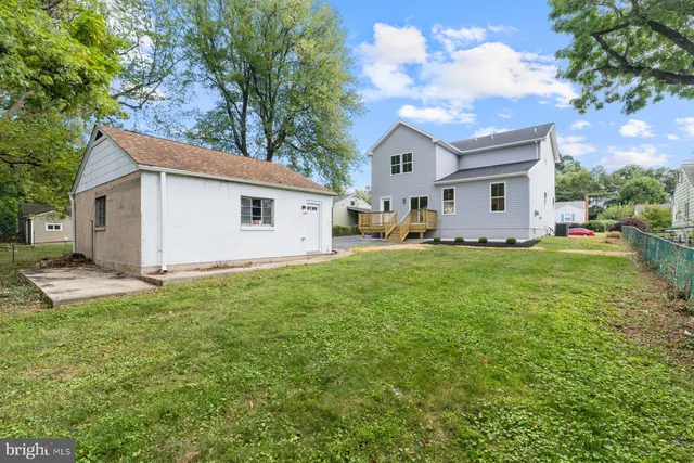 a big white house with a yard and large trees