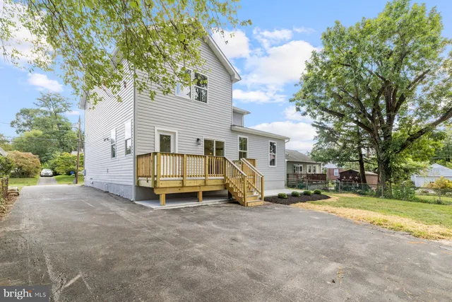 a view of a house with a big yard and large tree