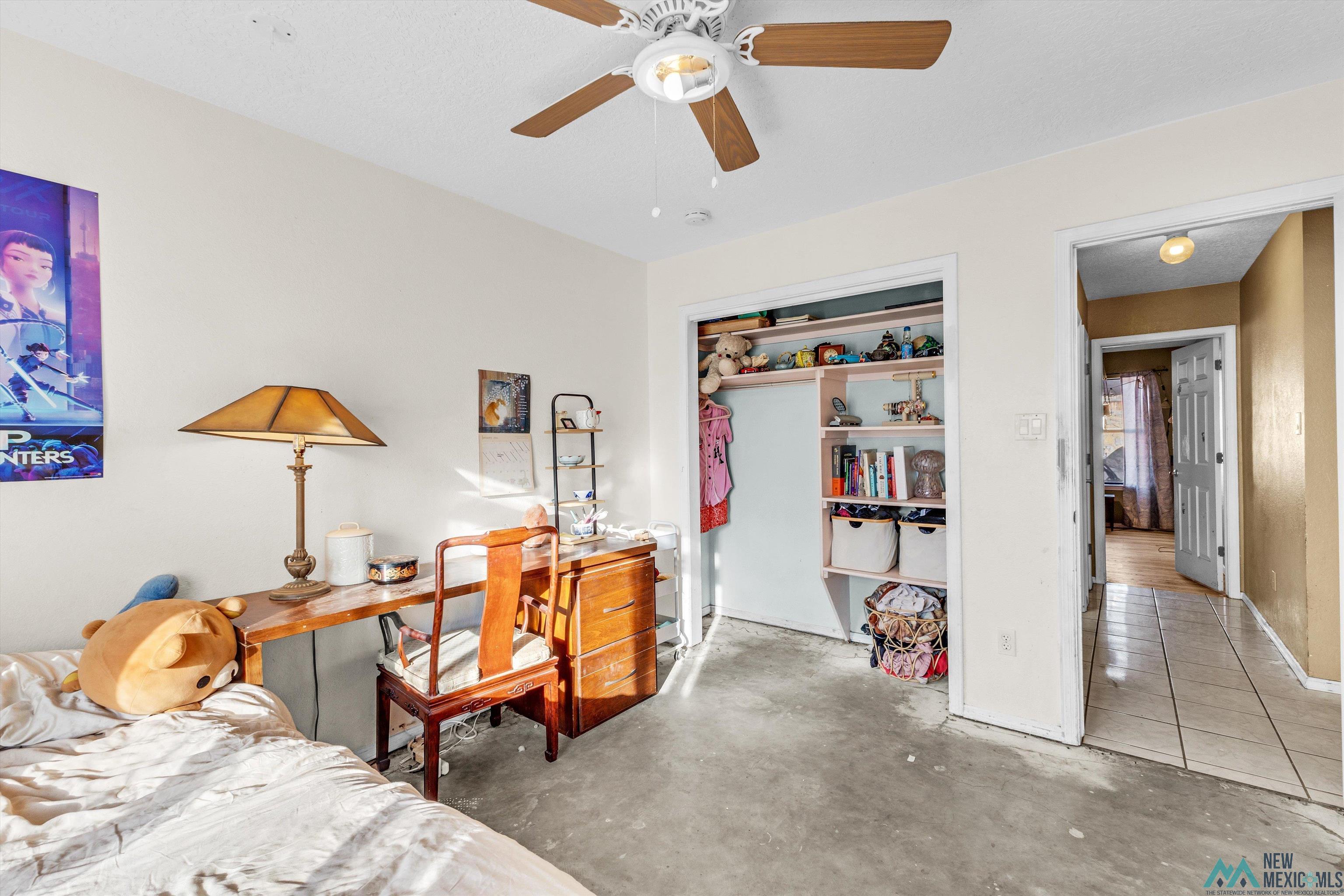 5008 Shadow Road Las Cruces, NM 88011 - Photo 8 of 35 Bedroom featuring a ceiling fan, concrete floors, and a closet