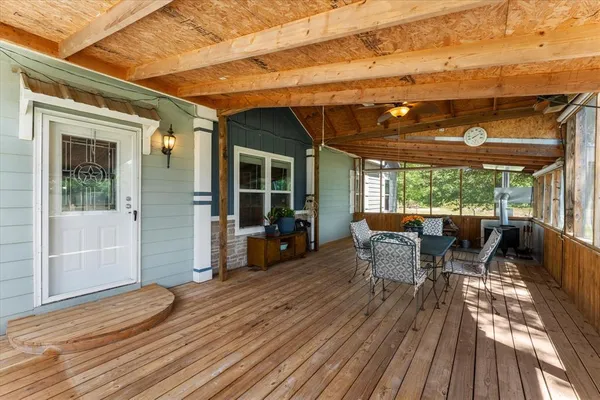 a view of a patio with table and chairs and wooden floor