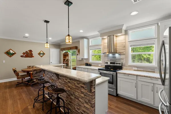 a kitchen with sink a stove and chairs