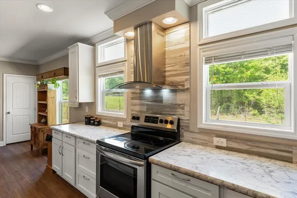 a kitchen with a stove a sink and a granite counter tops