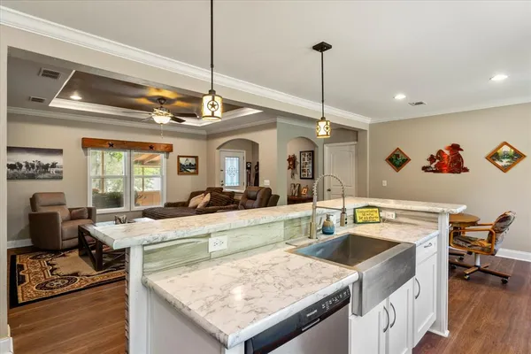 a kitchen island with stainless steel appliances granite countertop a sink stove and refrigerator