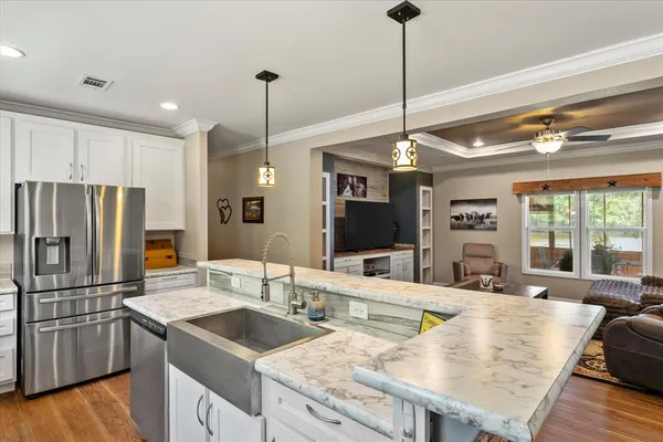 a kitchen with stainless steel appliances granite countertop a sink refrigerator and cabinets