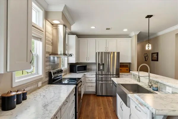 a kitchen with stainless steel appliances granite countertop a sink stove and refrigerator